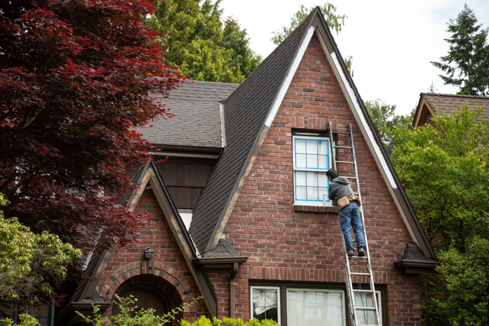 Painter,On,A,Ladder,Painting,The,Windowsill,Of,An,Old